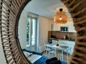 una vista di un soggiorno e di una cucina con uno specchio di Les Apparts de Marmande - Appart Cosy, centre de Marmande a Marmande