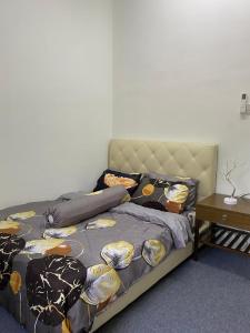 a bedroom with a bed and a table at Kencana L&K Homestay in Air Molek