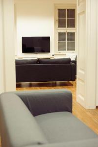 a living room with a couch and a flat screen tv at Hostel Folks in Bratislava