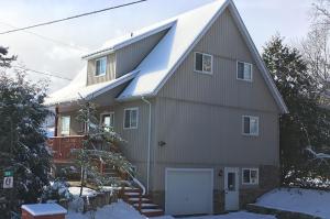 dom z pokrytym śniegiem dachem i garażem w obiekcie 106 Birch View Trail w mieście Blue Mountains