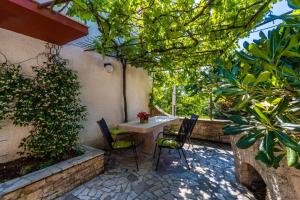 a patio with a table and chairs and plants at Apartments Perci in Krnica +14 photos