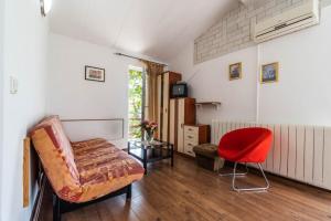 een woonkamer met een bank en een rode stoel bij Apartments Perci in Krnica