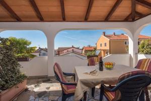 ノヴィグラード・イストラにあるApartment Nevaのバルコニーにテーブルと椅子が置かれたパティオ