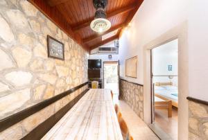 a long table in a room with a stone wall at House Linker in Kut