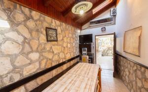 a room with a stone wall and a wooden bench at House Linker in Kut