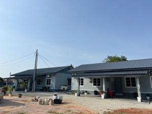 a group of houses with a car parked in front at Kencana L&K Homestay in Air Molek