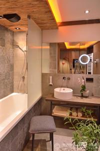 y baño con bañera, lavamanos y bañera. en Berghotel Pointenhof, en Sankt Johann in Tirol