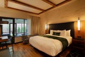 a hotel room with a large bed and a desk at The Swiftwater in Swiftwater