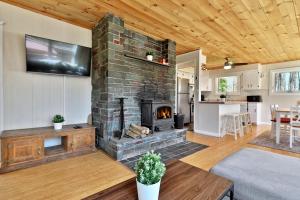 an open living room with a stone fireplace at Powder Park Place- Upper Unit of Duplex - Great for Groups, Ski Rental Ticket Deals! in Killington