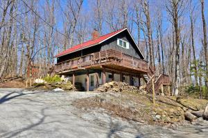 a house on top of a hill in the woods at Powder Park Place- Upper Unit of Duplex - Great for Groups, Ski Rental Ticket Deals! in Killington