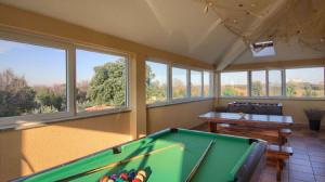 une salle de billard avec un billard et des fenêtres dans l'établissement House Kova, à Ližnjan