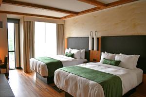 a hotel room with two beds with green sheets at The Swiftwater in Swiftwater
