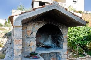 a stone oven with a fire inside of it at Apartment Goran in Nečujam