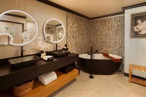 a bathroom with two sinks and a tub and mirror at The Swiftwater in Swiftwater