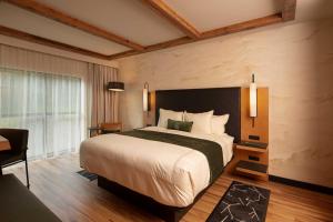 a hotel room with a large bed and a desk at The Swiftwater in Swiftwater