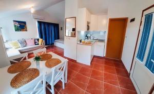 a living room with a table and chairs and a kitchen at Apartment Linda1 in Lumbarda