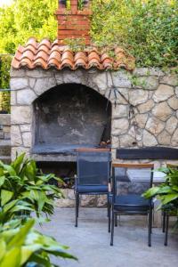 two chairs and a table in front of a stone oven at Apartments Diana in Dubrovnik