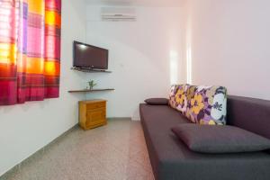 a living room with a couch and a flat screen tv at Apartments Diana in Dubrovnik