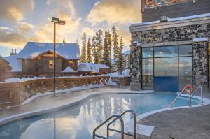 a resort swimming pool with snow on the ground at Stonegate Resort Unit B105 in Big White