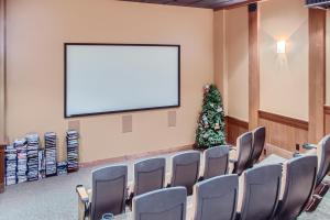 a conference room with a blank screen and a christmas tree at Stonegate Resort Unit B105 in Big White +26 photos