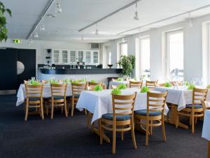 Un comedor con mesas blancas y sillas de madera. en 4 person holiday home on holiday park in Glesborg, en Glesborg