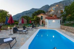 a villa with a swimming pool and a house at House Tonci in Tučepi