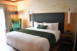 a bedroom with a large bed and a green chair at The Swiftwater in Swiftwater