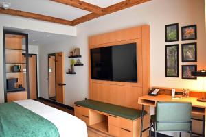 a bedroom with a bed and a desk and a television at The Swiftwater in Swiftwater