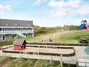 a playground with a building and a play park at 4 person holiday home in Ringkøbing in Ringkøbing