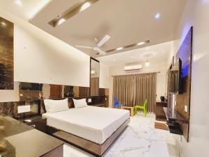 a bedroom with a white bed and a tv at M S RESIDENCY in Chennai