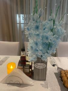 a vase of blue flowers sitting on a table at Hotel Consul in Sofia