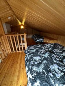 une chambre avec un lit dans une cabane en bois dans l'établissement Pyhän Patikka Holiday home, à Pyhätunturi
