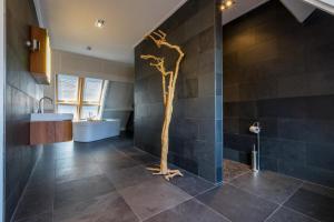 a bathroom with a tree in the middle of it at Welcome in - Appartement de Ijsvogel, in het centrum - Domburg in Domburg +24 photos
