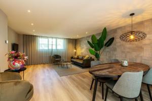 a living room with a table and a couch at Welcome in - Luxe appartement in de hoofdstraat, met balkon en airco - Domburg in Domburg