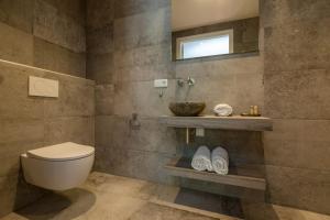 a bathroom with a toilet and a sink and a mirror at Welcome in - Luxe appartement in de hoofdstraat, met balkon en airco - Domburg in Domburg +31 photos