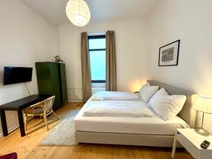 a bedroom with a bed and a desk and a window at FeWo Lessingstube nahe Jägermeister in Wolfenbüttel