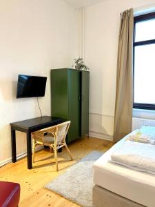 a bedroom with a desk and a green cabinet at FeWo Lessingstube nahe Jägermeister in Wolfenbüttel +11 photos
