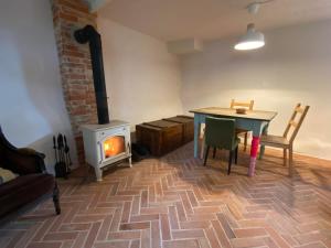 un soggiorno con un tavolo e una stufa a legna di Siedlisko Białe Błota a Skorzewo