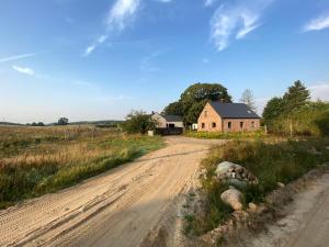 una strada sterrata vuota di fronte a una casa di Siedlisko Białe Błota a Skorzewo