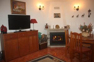 a living room with a television and a fireplace at Casa do Miradouro in Monsanto