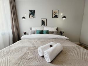 a bedroom with a large bed with towels on it at Apartament Diamond in Częstochowa