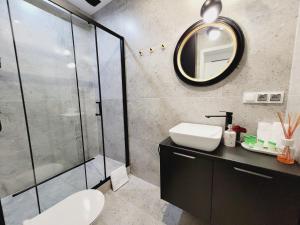 a bathroom with a toilet and a sink and a mirror at Apartament Diamond in Częstochowa +40 photos
