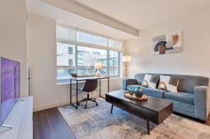 a living room with a couch and a table at Luxury Apt Near Kendall Square in Cambridge
