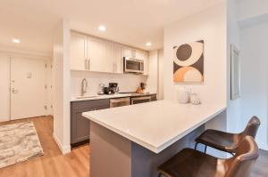 a kitchen with a counter and chairs in a room at Luxury Apt Near Kendall Square in Cambridge