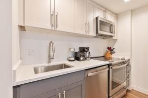a kitchen with white cabinets and a stainless steel sink at Luxury Apt Near Kendall Square in Cambridge +13 photos