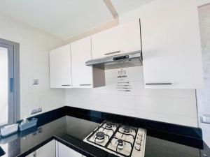 a kitchen with white cabinets and a stove top oven at The beautiful view in Tangier
