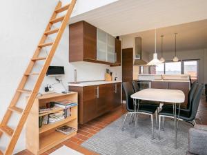 a kitchen and dining room with a ladder and a table at 5 person holiday home on a holiday park in Lemvig in Lemvig