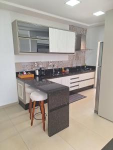 a kitchen with a black counter and white cabinets at Casa Bourbon in Foz do Iguaçu +11 photos