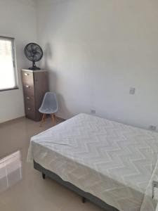 a bedroom with a bed and a dresser and a chair at Casa Bourbon in Foz do Iguaçu