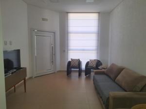a living room with a couch and chairs and a television at Casa Bourbon in Foz do Iguaçu
